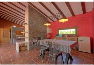 cocina y comedor con mesa y chimenea en Villa Jacinta, en Asprillas
