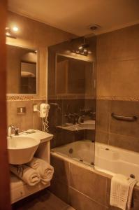 a bathroom with a sink and a bath tub at Los Robles Apart & Spa in San Carlos de Bariloche