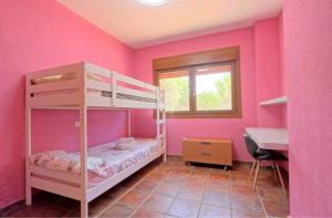 Habitación rosa con litera y escritorio. en Villa Jacinta, en Asprillas