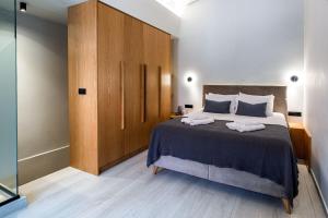 una camera con un grande letto e un armadio in legno di Chania Residence - City centre maisonette a Chania