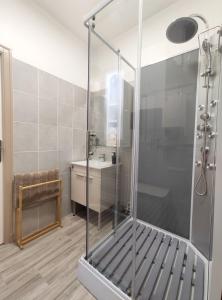 y baño con ducha y lavamanos. en Groom Épernay - Le Petit Tonnelier en Épernay