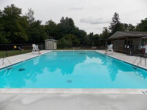 a large blue swimming pool with two chairs in it at The Family Getaway in Tobyhanna