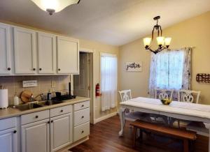 uma cozinha com armários brancos e uma mesa em The Family Getaway em Tobyhanna