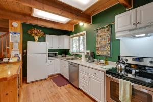 uma cozinha com electrodomésticos brancos e paredes verdes em Cozy Ashford Home - 5 Mi to Rainier Natl Park! em Ashford
