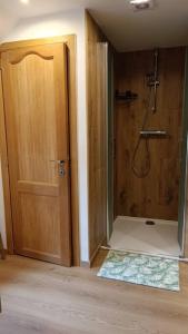 a bathroom with a shower and a wooden door at Jolie petite maison campagnarde 