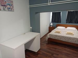 1 dormitorio con cama y escritorio blanco en Apartment Dipla 2 en Atenas