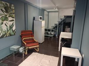 Zimmer mit einem Kühlschrank, einem Stuhl und einer Treppe in der Unterkunft Apartment Dipla 2 in Athen