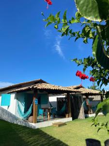 een huis met een rieten dak en een patio bij CHALÉ NAMORADA PATACHO in Pôrto de Pedras