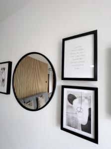 a mirror hanging on a wall with framed pictures at Apartament Latarnia in Władysławowo