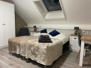 a bedroom with a bed and a table with chairs at B&B Plompetorenzicht in Burgh Haamstede