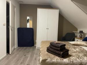ein Schlafzimmer mit einem Stapel Handtücher auf einem Bett in der Unterkunft B&B Plompetorenzicht in Burgh Haamstede