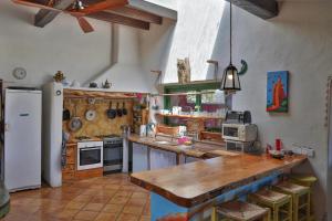 Villa Turquoise Formentera في سانت فيران دي سيس روكيه: مطبخ مع كونتر خشبي علوي وثلاجة