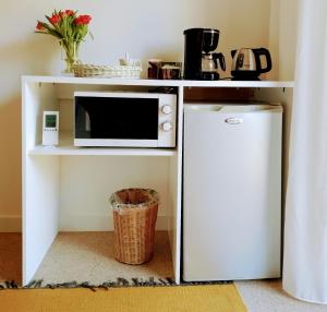a microwave on a shelf next to a refrigerator at De Sprokkel in Milsbeek