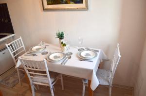 a white table with chairs and plates on it at Apartment Anita Međugorje in Međugorje +25 photos