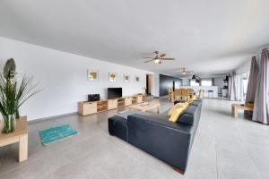 a living room with a blue couch and a table at Casa Eden naturist area, full privacy, relax and private pool in Charco del Palo