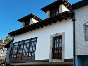 une maison blanche avec des fenêtres marron dans l'établissement Casa de Aldea el Pontón, à Cue
