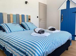ein blau-weißes gestreiftes Bett mit Handtüchern darauf in der Unterkunft Sweet Home Paradise in Villers-le-Lac