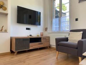 sala de estar con TV de pantalla plana en la pared en Sweet Home Paradise en Villers-le-Lac