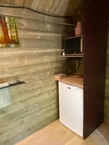 uma cozinha com uma parede de madeira e um micro-ondas em Le Dôme de Namur - Une nuit insolite dans les bois em Champion