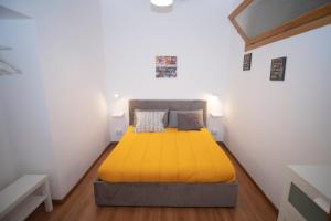 ein Schlafzimmer mit einem gelben Bett in einem weißen Zimmer in der Unterkunft Donna Rosaria House in Sorrent