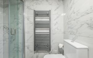 a bathroom with a toilet and a glass shower at Lovely Cottage in North Creake +33 photos