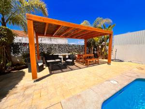 une pergola en bois à côté d'une piscine dans l'établissement Villa Sol, à Ferragudo