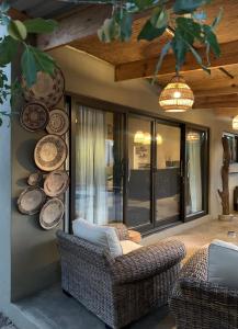 una sala de estar con sillas y platos en la pared en Rooibos Luxury Bush Cottage en Hoedspruit