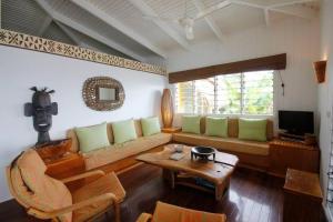 a living room with a couch and a table at Beachfront Villa - House of Bamboo, Infinity Pool in Savusavu