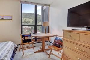 um quarto com uma mesa e uma grande janela em MP522 Mountain Plaza Hotel Room em Copper Mountain