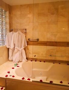 uma casa de banho com banheira com rosas no balcão em Hotel Las Lomas em Lima
