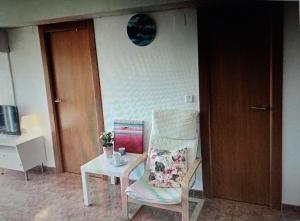 een kamer met een stoel, een tafel en een klok bij Nice apartment on the coast to relax and work in Cartagena