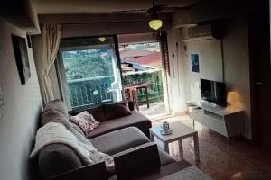 een woonkamer met een bank en een groot raam bij Nice apartment on the coast to relax and work in Cartagena
