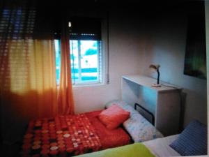 een slaapkamer met een bed en een raam bij Nice apartment on the coast to relax and work in Cartagena