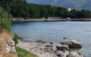 科托尔3 Bedroom Awesome Home In Dobrota的一大片水体,有岩石和树木