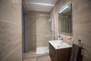 a bathroom with a shower and a sink and a mirror at Seaside Luxury Apartment in St. Paul's Bay