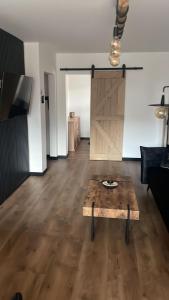 - un salon avec une table en bois et une porte de grange dans l'établissement Apartament Boho, à Międzyzdroje