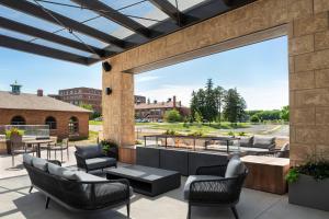 eine Terrasse mit Sofas, Tischen und Stühlen in der Unterkunft SpringHill Suites by Marriott Milwaukee West/Wauwatosa in Wauwatosa