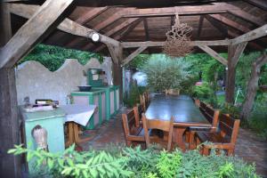 a wooden pergola with a wooden table and chairs at Vikendica Despotovic in Bijeljina