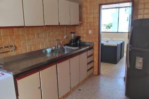 a kitchen with a sink and a refrigerator at Apartamento con vista al mar en la mejor zona de la ciudad genial para relax o trabajo in Ríohacha