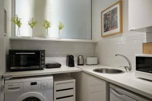 a kitchen with a sink and a microwave and a dishwasher at Parthenon Apartment in Athens