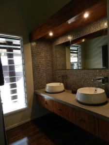 baño con 2 lavabos y espejo grande en Beachfront Villa - Pod House, Private Plunge Pool, en Savusavu