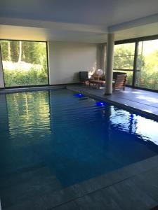 uma piscina com luzes azuis numa casa em Le Dôme de Namur - Une nuit insolite dans les bois em Champion