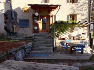 einen Tisch und Stühle vor einem Haus in der Unterkunft Rifugio Uschione in Chiavenna