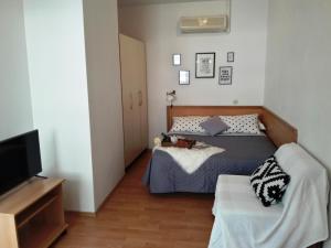een kleine slaapkamer met een bed en een televisie bij Apartments Milena & Ante in Makarska