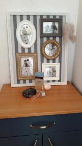 a dresser with pictures on the wall and a desk at Apartments Milena & Ante in Makarska