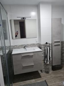 y baño con lavabo, espejo y ducha. en Arrecife-Playa del Reducto Apartment, en Arrecife