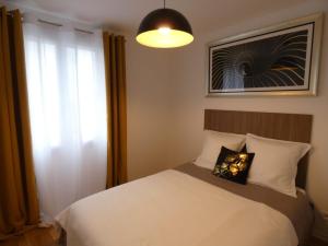 ein Schlafzimmer mit einem weißen Bett und einem Fenster in der Unterkunft Les jardins du Carrousel - Chambre privée aménagée en T2 in Noisy-le-Grand