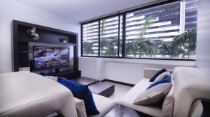 sala de estar con sofá y TV de pantalla plana en Bellini I 2, 2 habitaciones, Puerto Santa Ana, Guayaquil, en Guayaquil