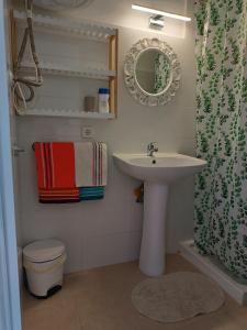 W łazience znajduje się umywalka, toaleta i lustro. w obiekcie Hostal Bélgica w miejscowości Palma Nova