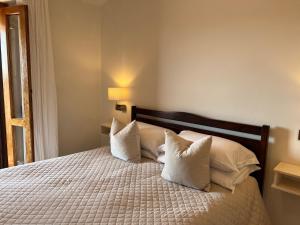 1 dormitorio con 1 cama con almohadas blancas en Villa Lavinia B&B en Montescudaio